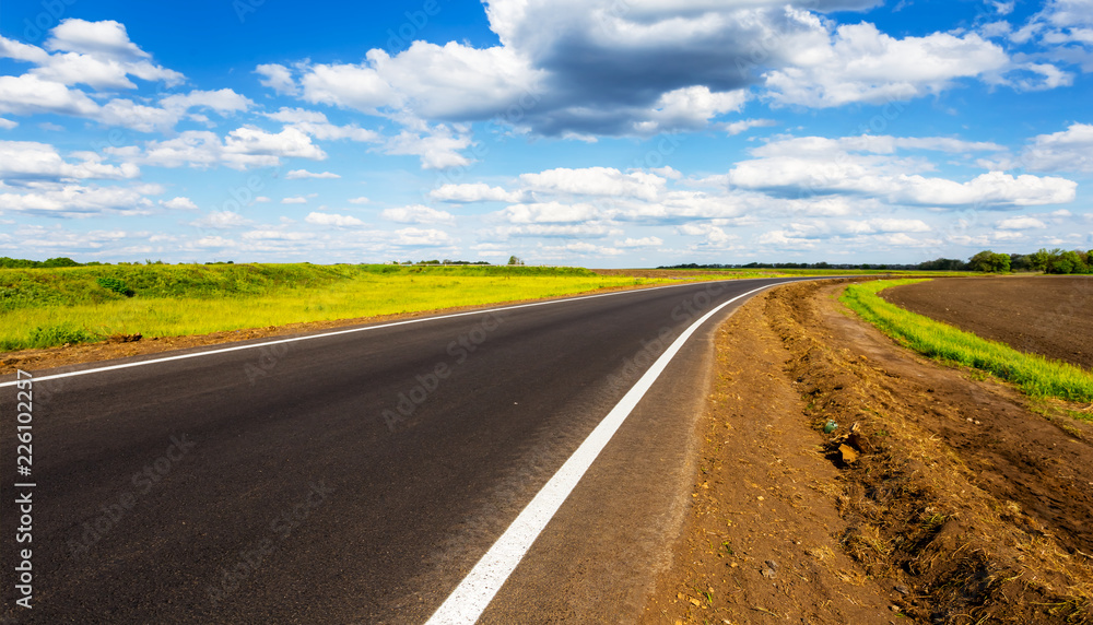 Fototapeta premium asphalt road turn under a blue cloudy sky