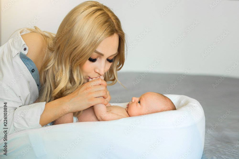 Obraz premium beautiful young mother with flowing hair holding the hand of her young child