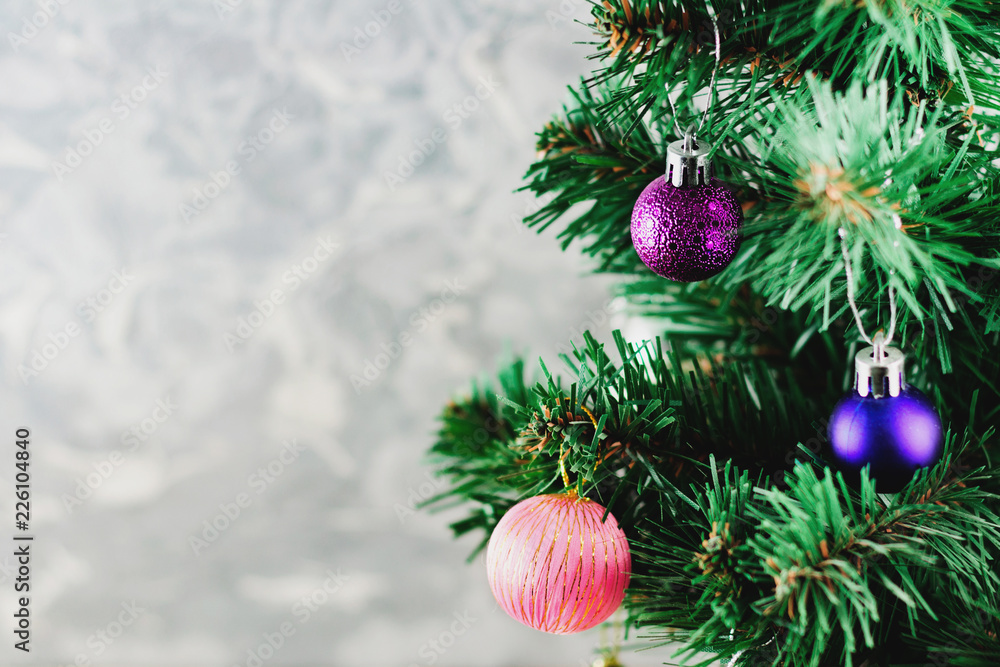 Twigs of christmas tree with balls on background of gray concrete wall. Christmas concept. Copy space for your text