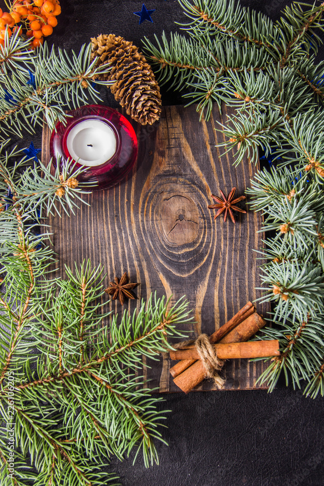 Christmas tree branch red candle cinnamon sticks Badyan ashberry on a wooden background Christmas tree branch red candle cinnamon sticks Badyan ashberry on a wooden background