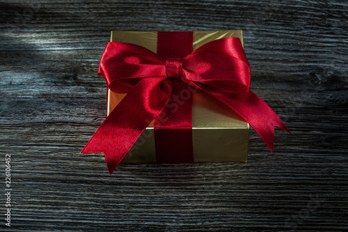 Packed golden present box on wooden board