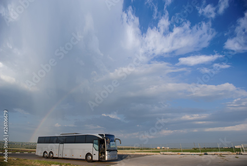 Bus staying in the parking lot under a blue sky with clouds