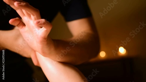 Wallpaper Mural Massage of the lower part of the female leg with oil on the background of candles in a dark room Torontodigital.ca