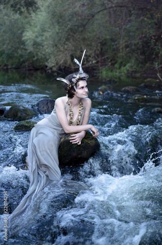 Quadro su tela seductive mermaid resting in a waterfall among the river stones and looking into