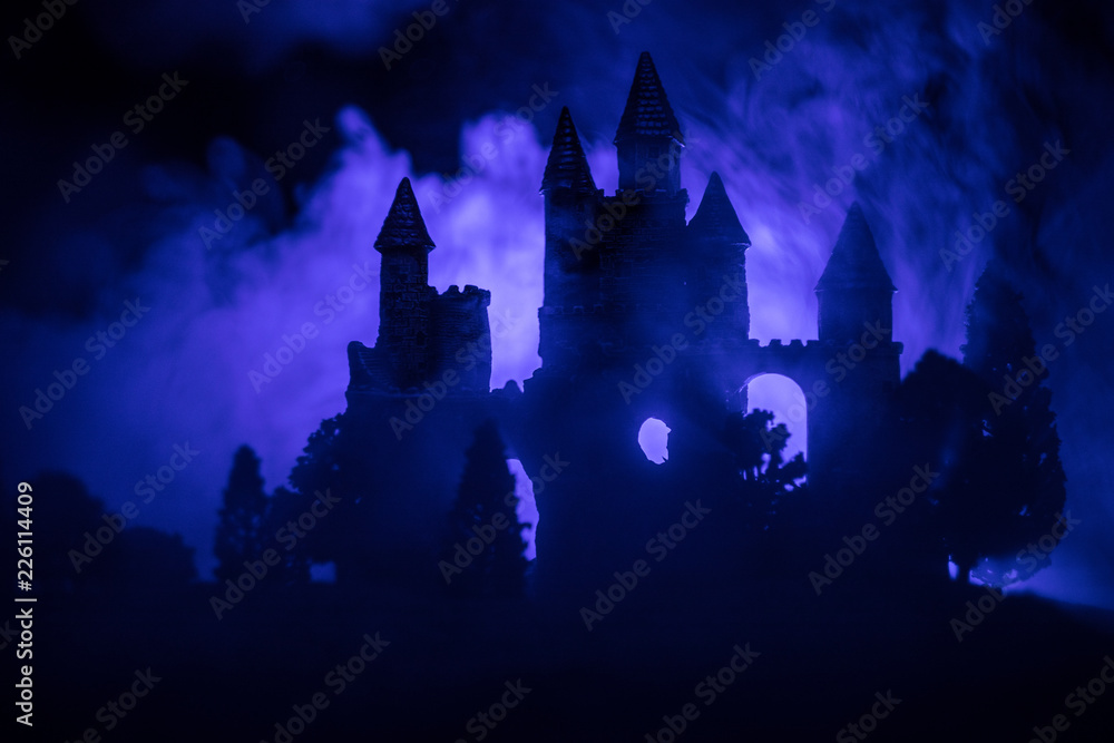 Mysterious medieval castle in a misty full moon. Abandoned gothic style old castle at night