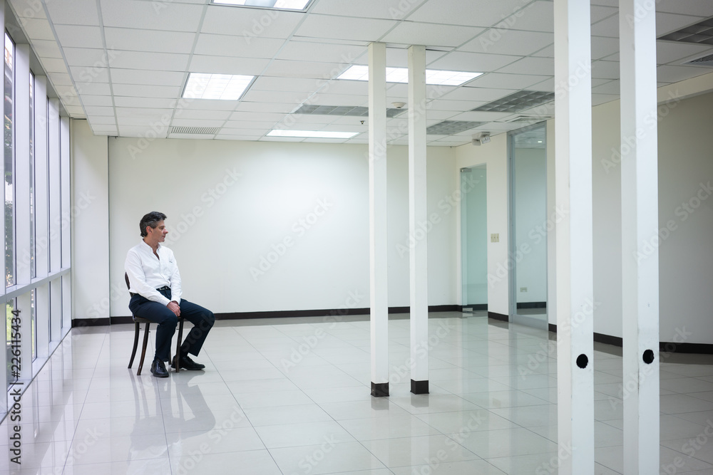 Businessman seating in empty bright office and look inside thinking Businessman seating in empty bright office and look inside thinking