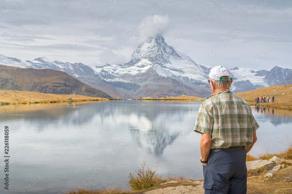 Old man enjoying the view from lake Stellisee, Swiss Alps , Matterhorn Peak, Zermatt, Switzerland