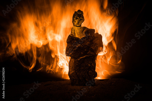 Horror silhouette of scary figure at night. Female demon. Demons coming. Slhouette of devil or monster figure on a background of fire.