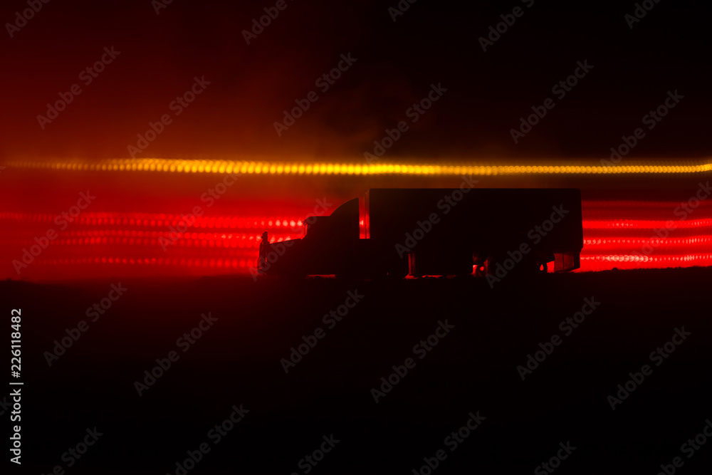 Obraz premium Big truck wagon rides on the road outside the city at night with foggy background. Decoration
