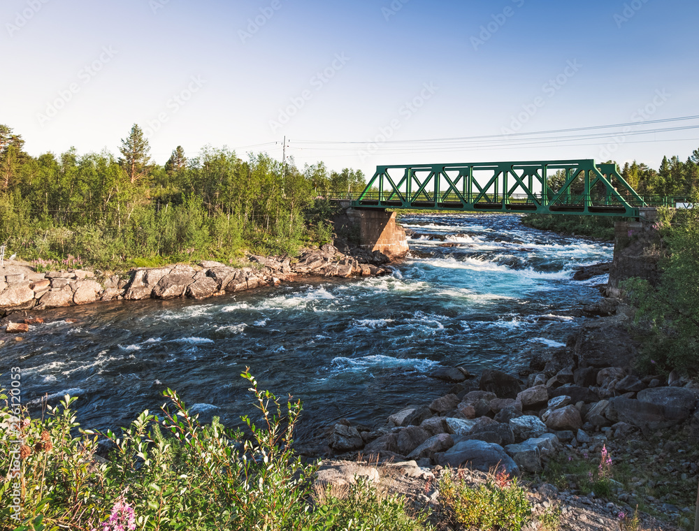 Fototapeta premium Picturesque panorama view of the railway bridge over the Rautas River near Rautas village in Kiruna municipality, Norrbotten, Sweden.