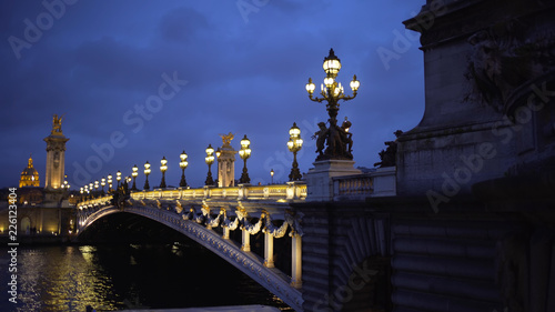 Romantic scenery with lights and sculpture on historic French bridge in Paris