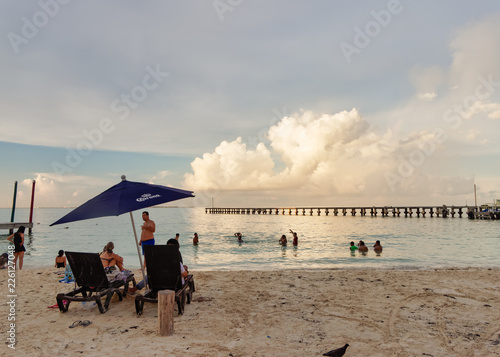 Tropical beach with bathers under the umbrella, Playa Caracol, Boulevard Kukulcan, Zona Hotelera, Cancún, Mexico, in September 8, 2018 photo