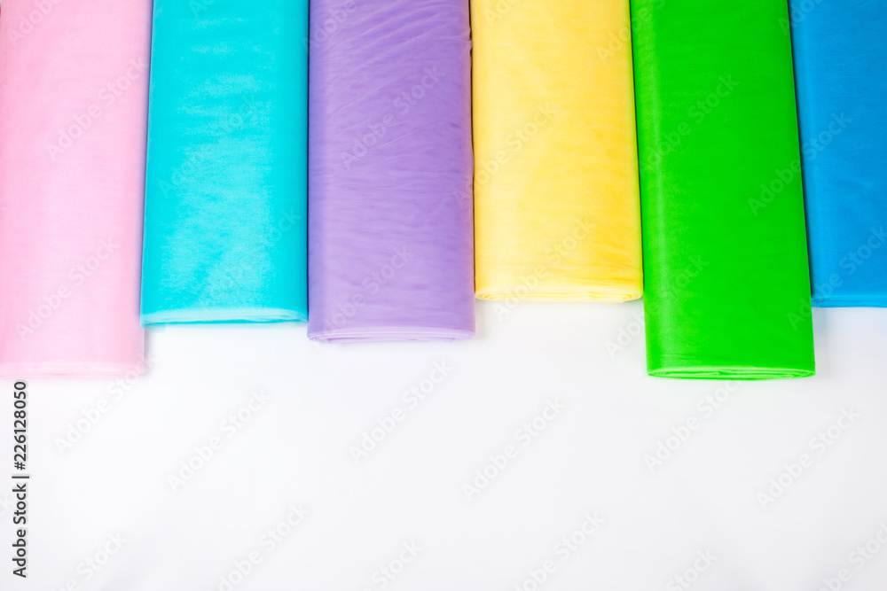 Colorful fabric rolls in warehouse - isolated on white background