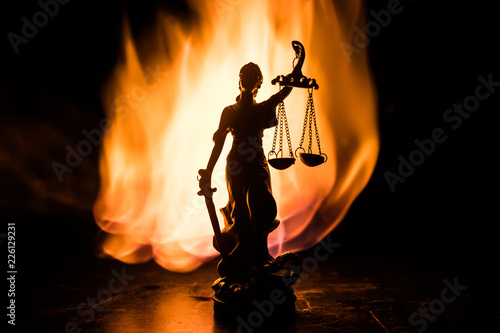 The Statue of Justice - lady justice or Iustitia / Justitia the Roman goddess of Justice on a dark fire background