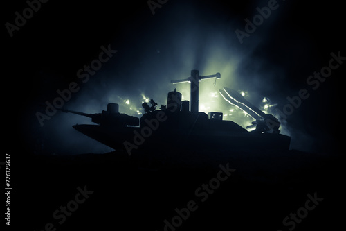 Sea battle scene. Silhouette of military war ship on dark foggy toned sky background. Explosion and fire. Dramatic scene decoration.
