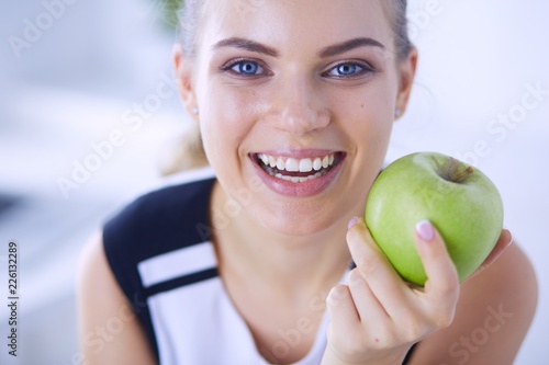 Close up portrait of healthy smiling woman with green apple.