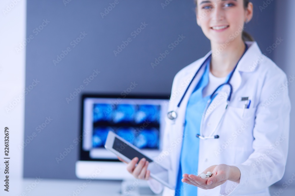 shot of doctor holding pills and tablet at clinic. shot of doctor holding pills and tablet at clinic.