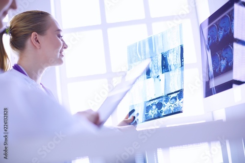 female doctors looking and discussing x-ray image at hospital.