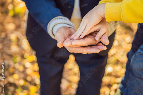 A child's hand holding the hand of an old man