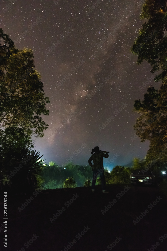 Silhouette of a cameraman will shooting a milky way