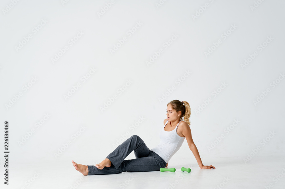 young woman sitting on the floor in an isolated background