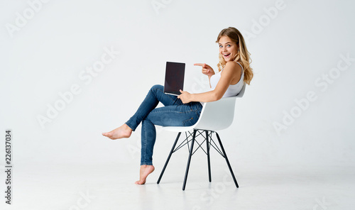 joyful woman sitting on a chair with a laptop
