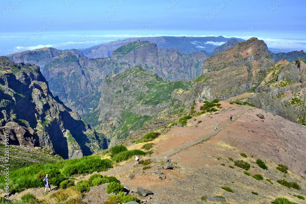 Naklejka premium Tourists near the top of Pico do Arieiro one of the highest peaks in Madeira island. Hiking trail from Pico do Arieiro to Pico Ruivo. 