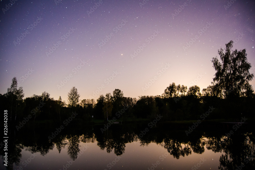 Lights from a nearby town glow in the night sky creating light pollution making it difficult to see the stars