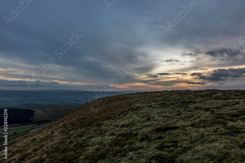 From top of hill captured colored sunset with many clouds