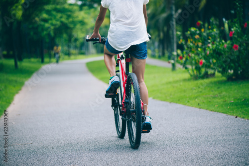 Woman riding mountain bike in tropical park