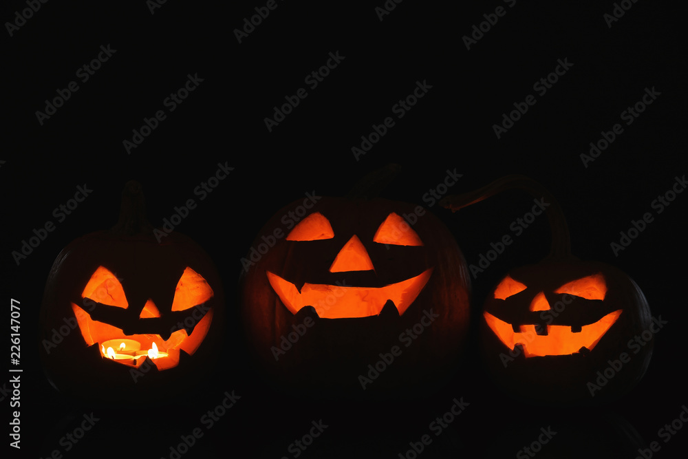 Halloween pumpkin heads. Glowing jack lanterns in dark Halloween pumpkin heads. Glowing jack lanterns in dark