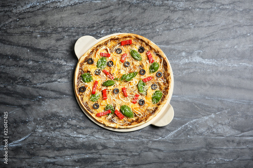 Board with delicious homemade pizza on marble background, top view