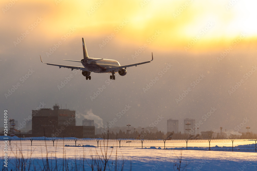 On a snowy winter evening, a jet plane lands at Sheremetyevo Airport in Moscow, Russia On a snowy winter evening, a jet plane lands at Sheremetyevo Airport in Moscow, Russia