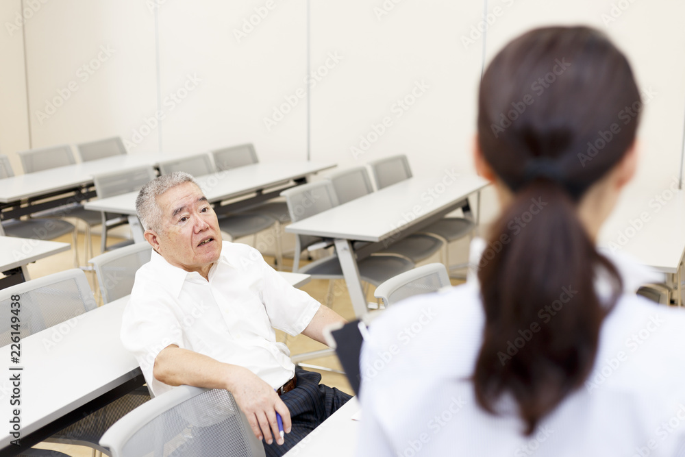 Obraz premium 会議をする女性と高齢の男性