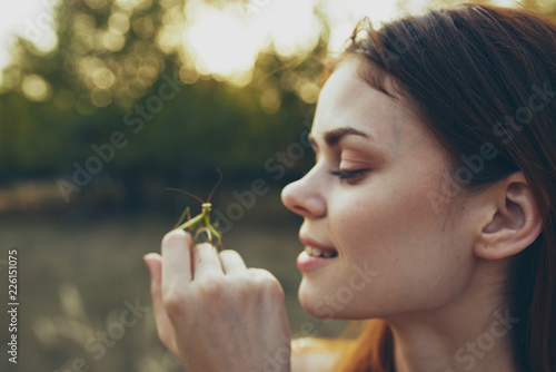woman smiling holds on the hand grasshopper village summer nature