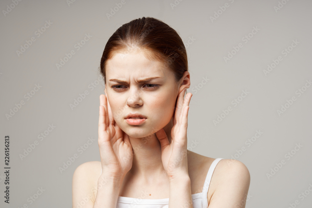 a woman's ears hurt on a light background a woman's ears hurt on a light background
