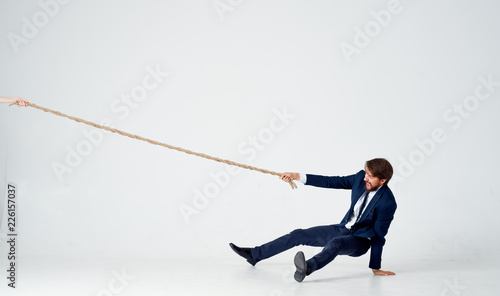 strong man in suit pulls the rope on an isolated background