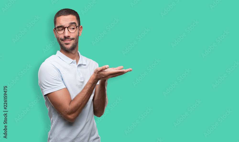 Concept of a happy young man holding something with his hand Concept of a happy young man holding something with his hand