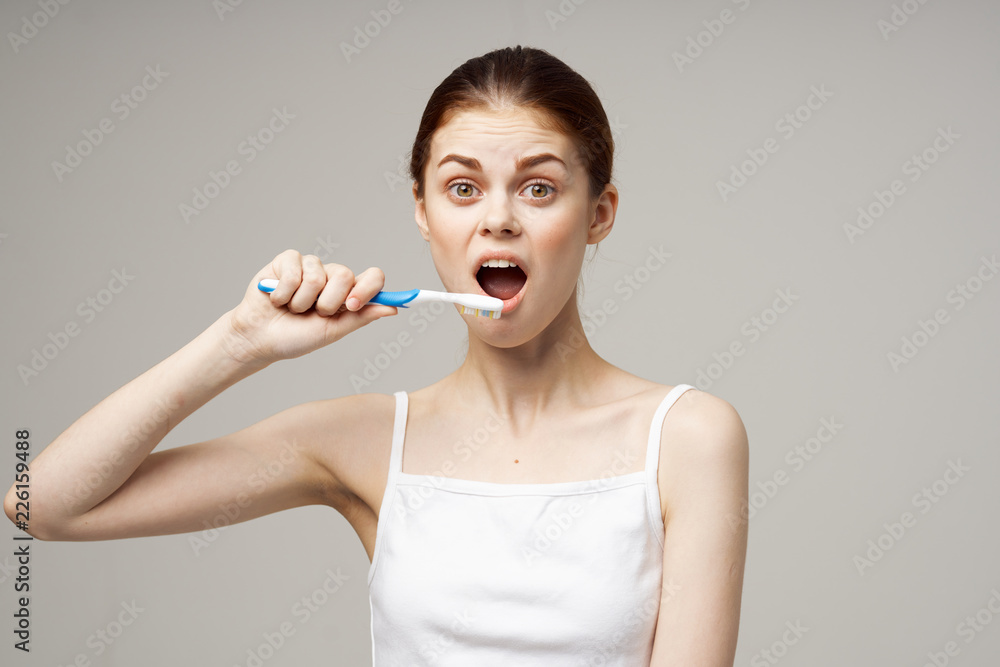 woman brushing her teeth with a toothbrush woman brushing her teeth with a toothbrush