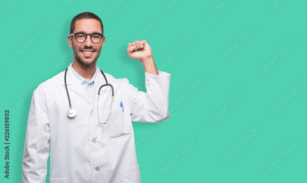 Happy young doctor celebrating with his fist up Happy young doctor celebrating with his fist up