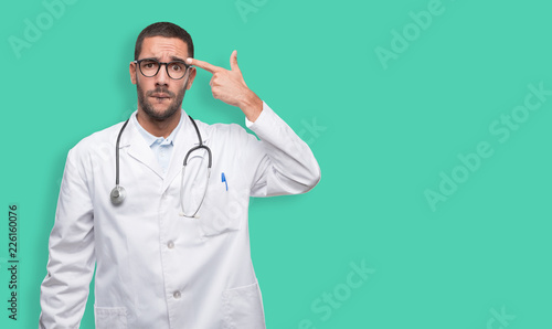 Depressed young doctor doing a suicide gesture