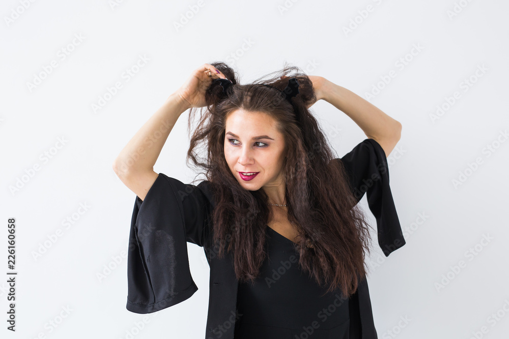 Halloween and masquerade concept - Beautiful young woman posing in light background Halloween and masquerade concept - Beautiful young woman posing in light background
