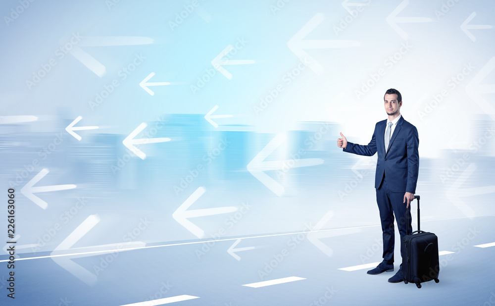 Young businessman hitchhiking near the city with arrows around concept Young businessman hitchhiking near the city with arrows around concept