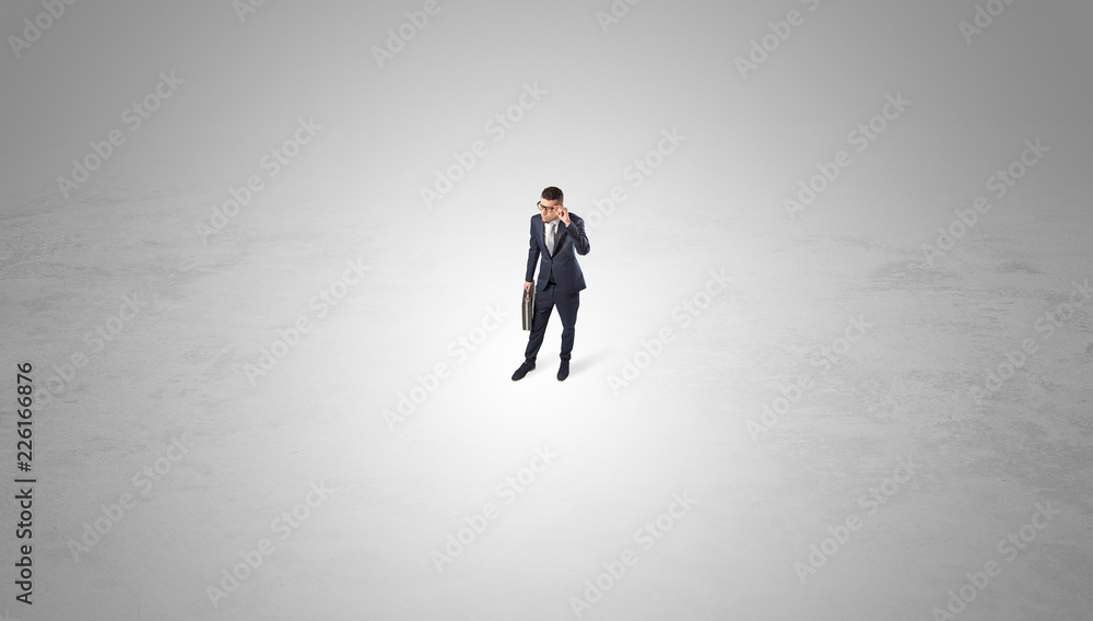 Young businessman standing alone in the middle of an empty space
Young businessman standing alone in the middle of an empty space