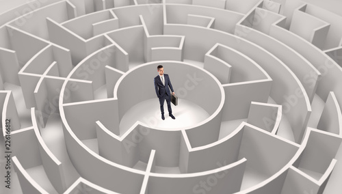 Young businessman standing in a middle of a 3d round maze 