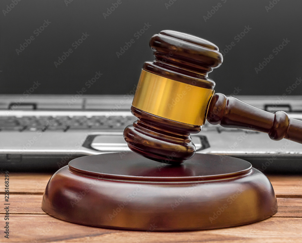 Judge's gavel with laptop on the table. Judge's gavel with laptop on the table.