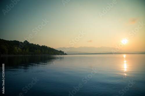 A beautiful  calm morning landscape of lake and mountains in the distance. Colorful summer scenery with mountain lake in dawn. Tatra mountains in Slovakia  Europe.