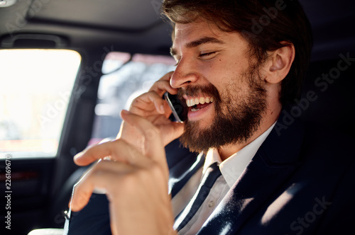 smiling business man talking on the phone sits behind the wheel © SHOTPRIME STUDIO