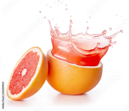red juice splashing out of a grapefruit isolated on white background