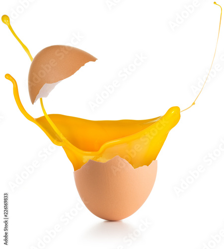 yolk splashing out of a broken egg isolated on white